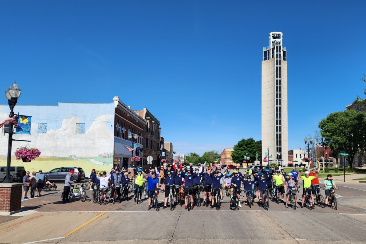 Large group of cyclists pose in crosswalk