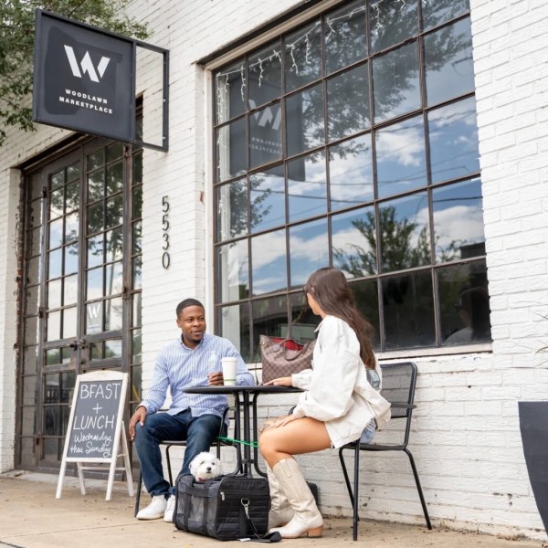 Two people sit at bistro table.
