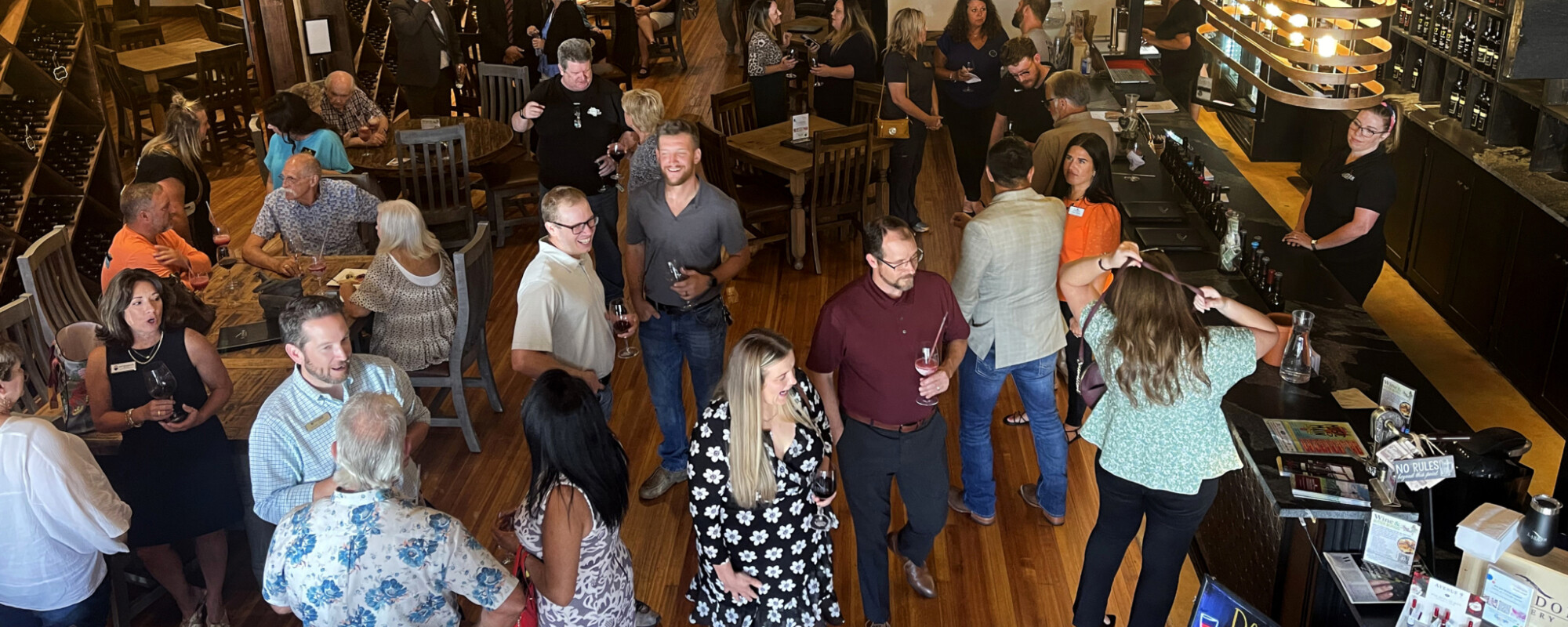 People socialize at an event in a winery