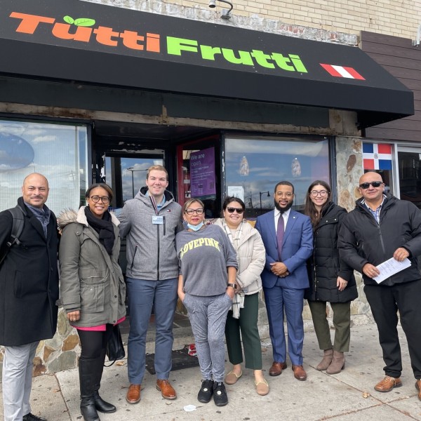 People stand pose for a group photo in front of a restaurant.