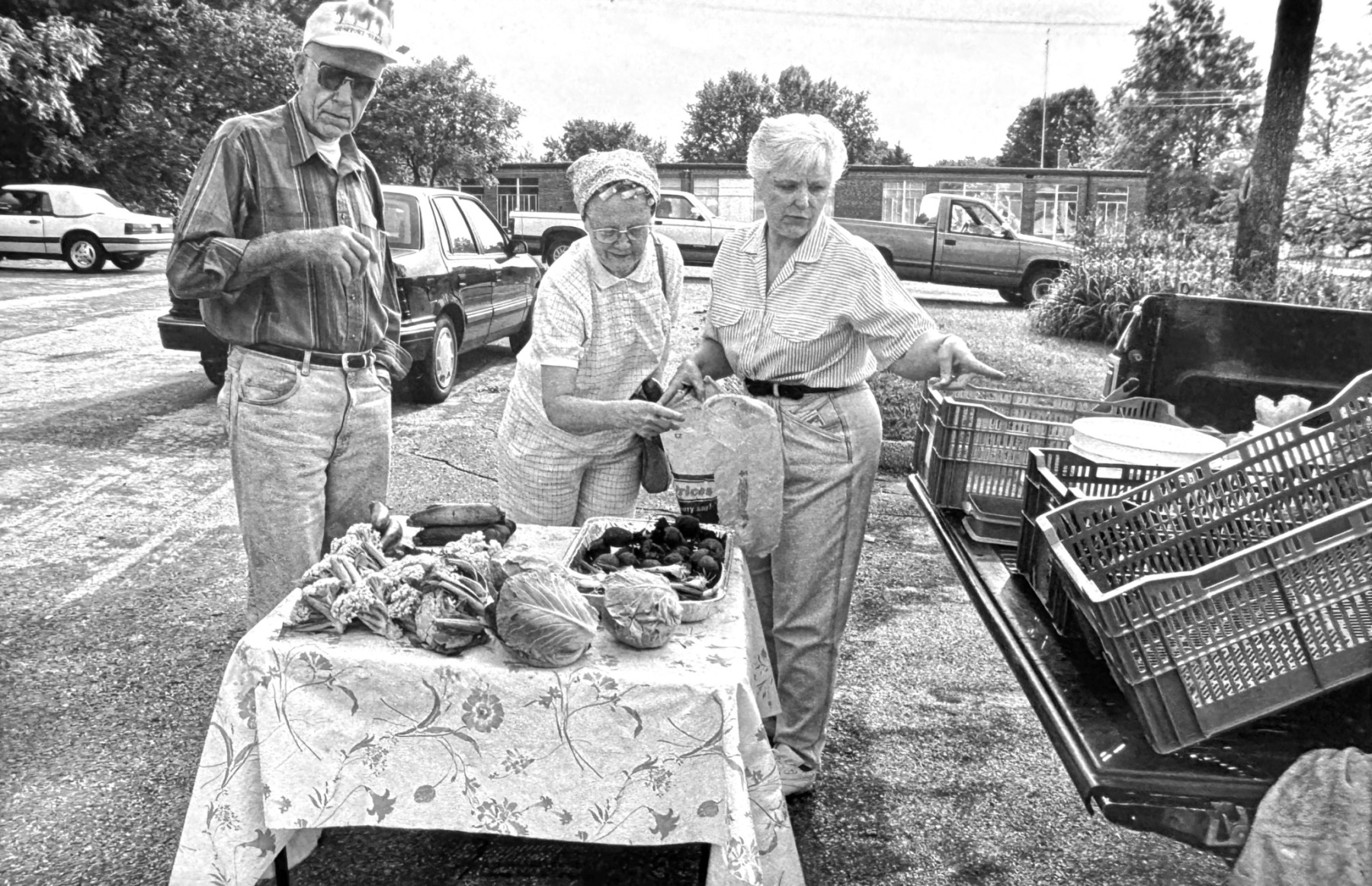 Black and white photo of people shopping at a farmers market