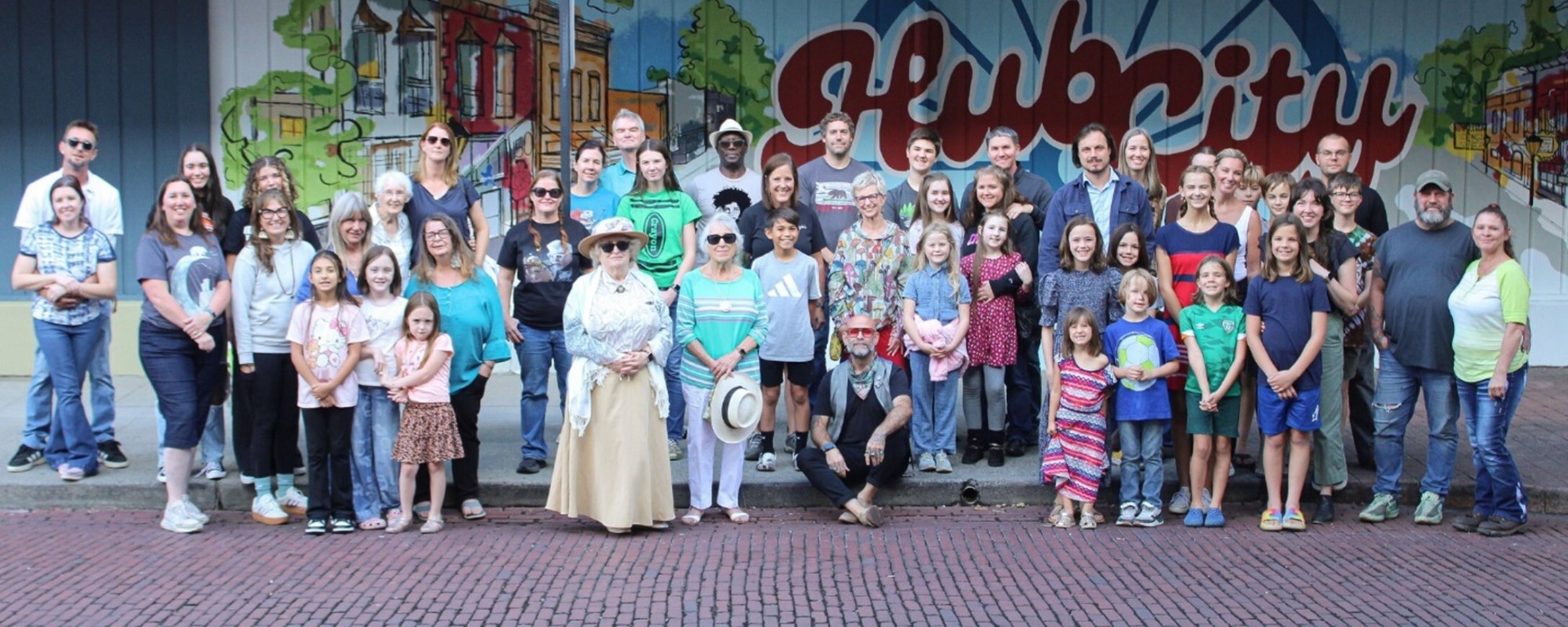 A large group of people in front of a mural celebrating Centralia's history