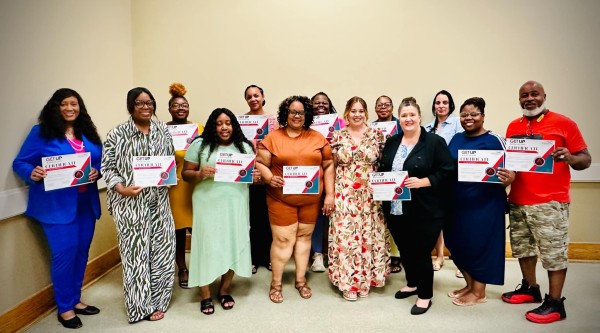 A group of people holding graduation certificates