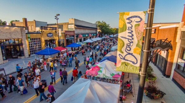 Aerial shot of downtown street filled with pedestrians and booths.