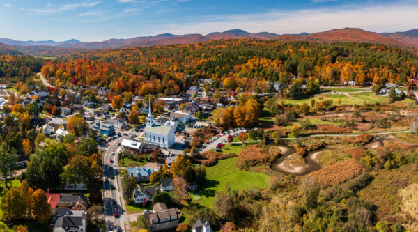 Vibrant fall colors across a hilly landscape dotted with historic buildings