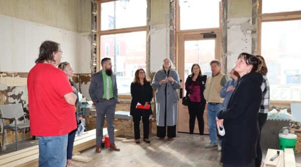 A group of people looking up at the ceiling while touring a historic space