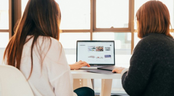 Two women looking at a website on a laptop