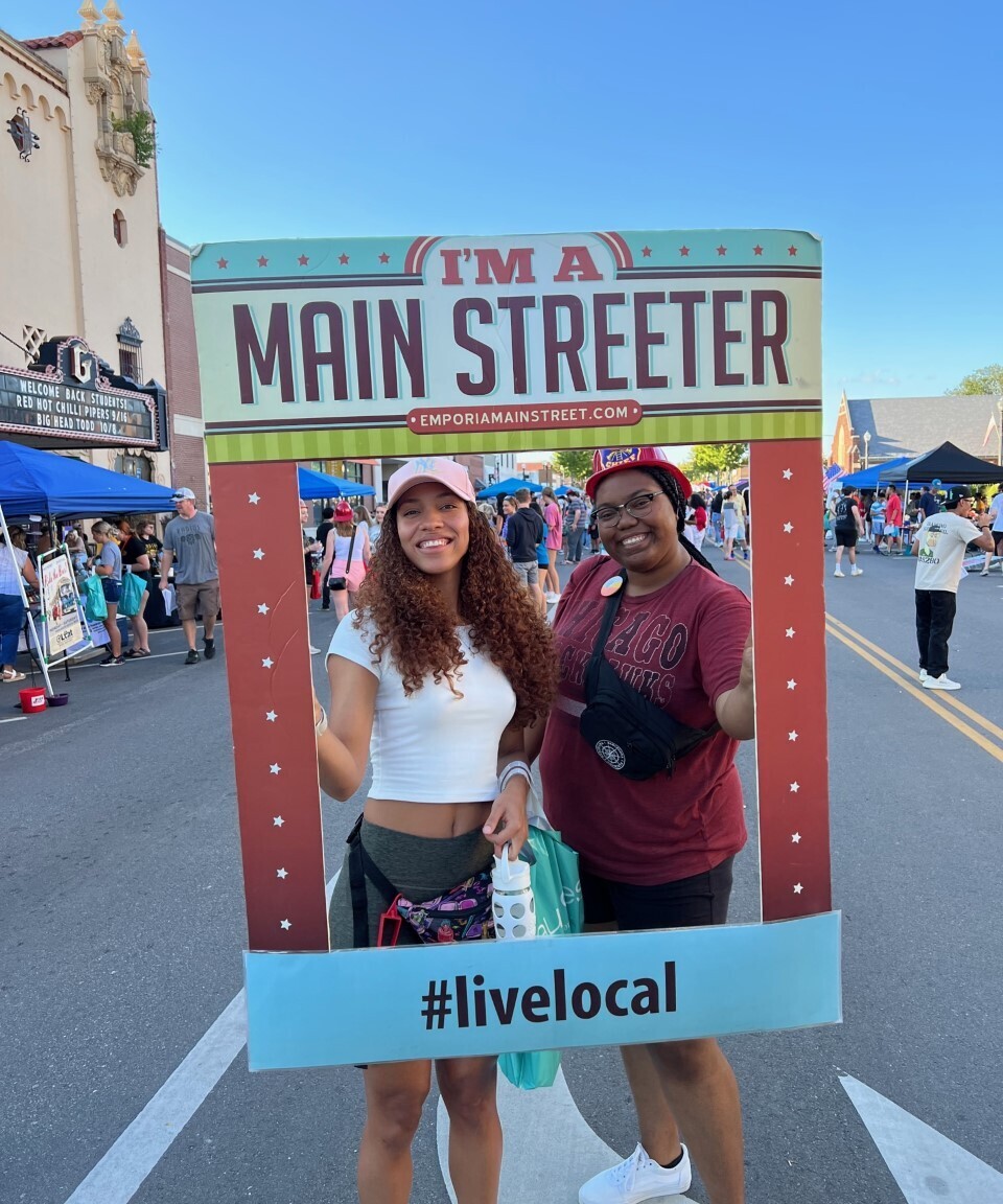 Two community members in Emporia Kansas pose with a sign saying "I'm a Main Streeter"