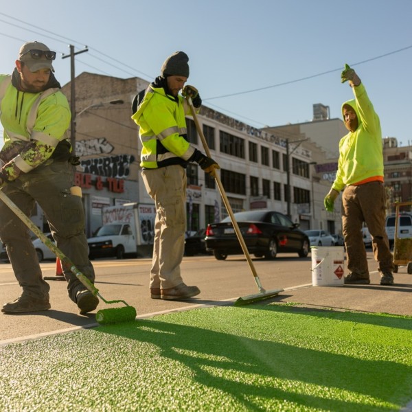 City workers painting markings on a street