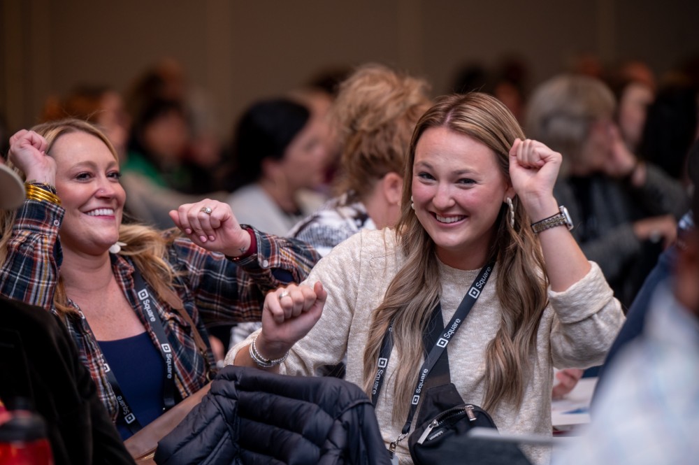 Women smile while dancing in their seats.