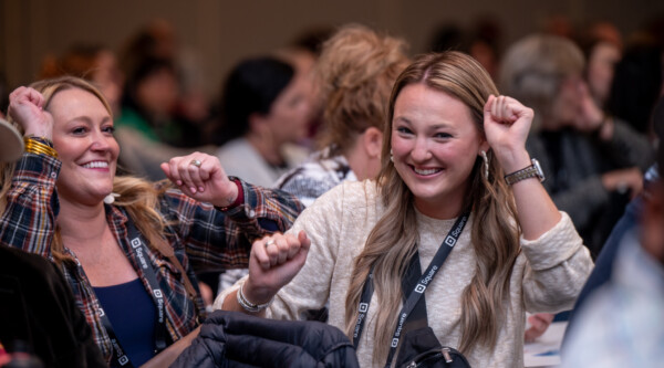 Women smile while dancing in their seats.