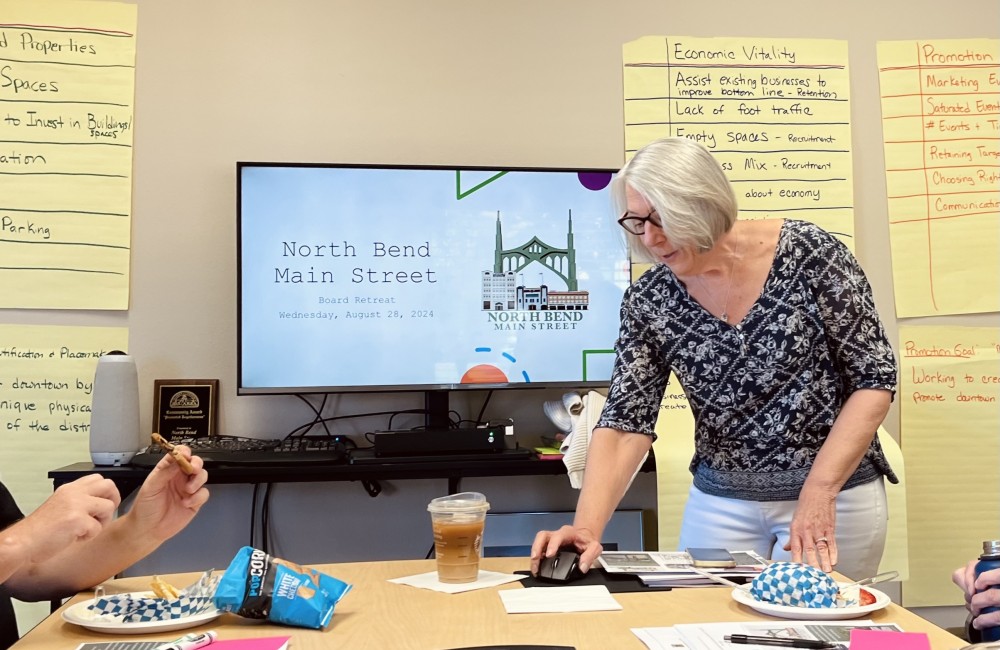 Photo of a woman presenting in small conference room.