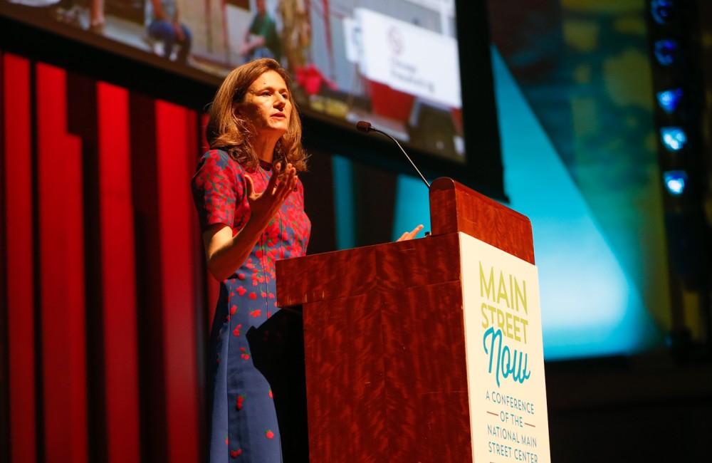 Woman speaking from behind a podium.