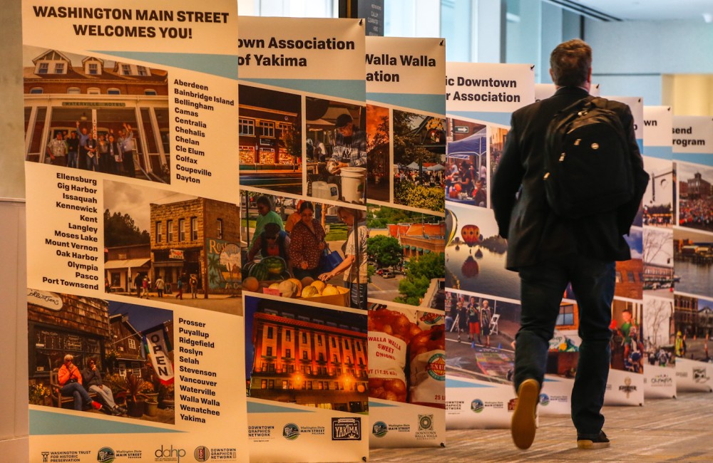 A man walks past pop-up banners.