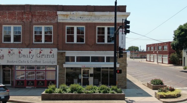 Historic red brick corner building with a coffee shop