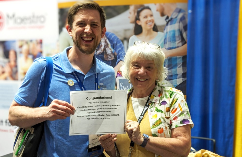 Two people pose for a celebratory photo.