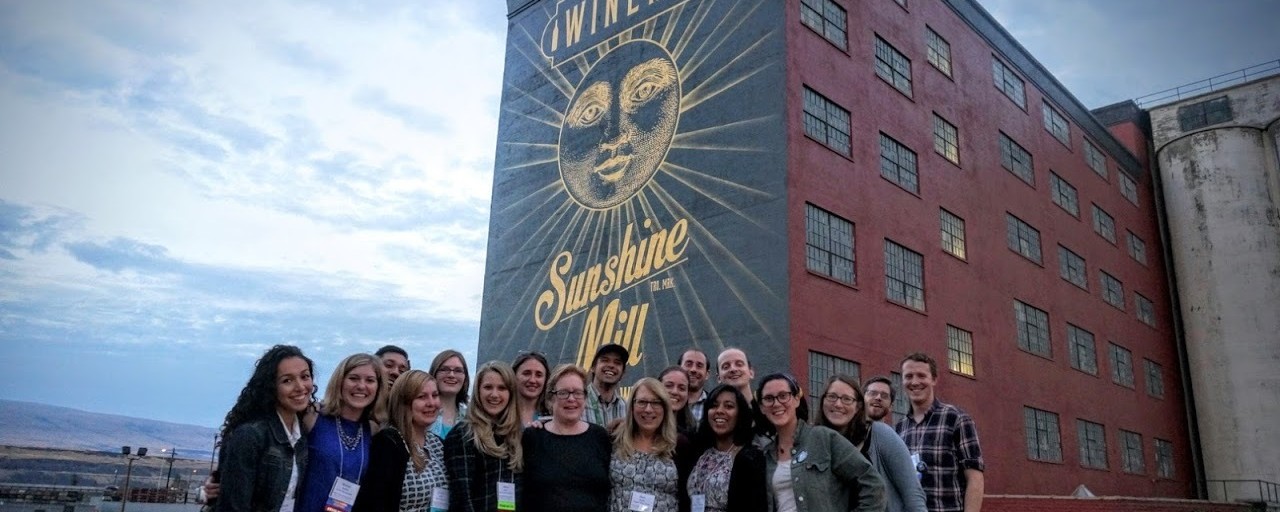Large group of people in front of Sunshine Mill Winery mural.