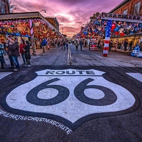 Large route 66 sign street art on the pavement outside a bustling street market