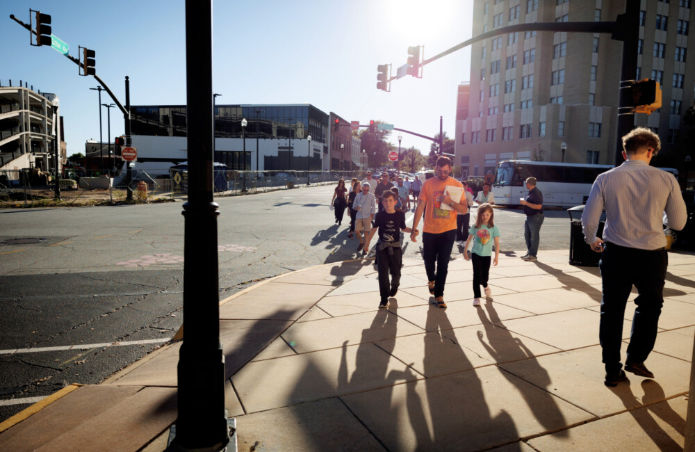 A small family walks down a small town sidewalk.