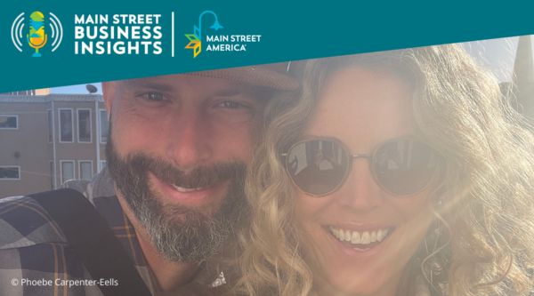 Man with beard and baseball cap smiles with woman with curly blonde hair and aviator sunglasses.