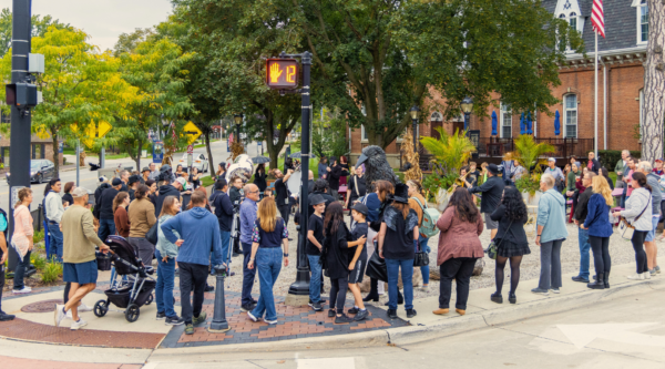 A large crowd of people standing on a street corner